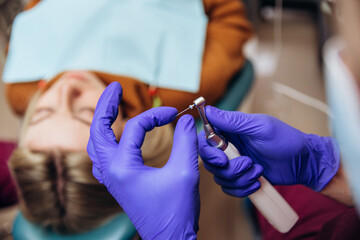 Closeup picture of dental instruments: drill and needle for root canal treatment and pulpitis in hand at the dentist