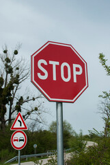 Country road bend with red stop traffic sign closeup