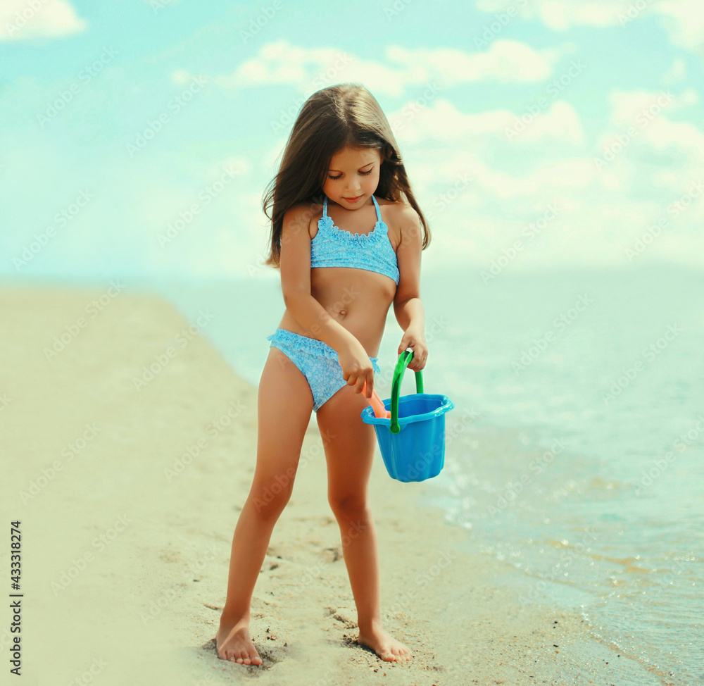 beach little garl Child little girl playing with toys on a beach in summer day の Stock フォト |  Adobe Stock