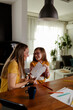 © Nebojsa - Mom daughter time. Happy daughter gives her mother an postcard.
