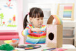 © M-image - young girl making bird house craft for home schooling