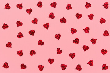 Wall Mural - red heart shaped confetti pattern on pink abstract background.