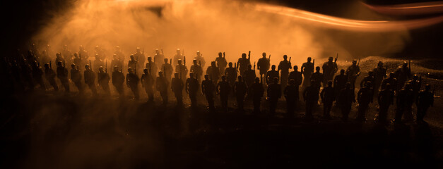 War Concept. Military silhouettes fighting scene on war fog sky background, World War Soldiers Silhouette Below Cloudy Skyline At night. Battle in ruined city.