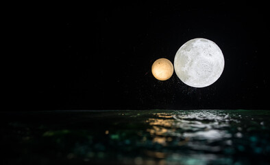 Wall Mural - Romantic and scenic panorama with full moon on sea to night. Table decoration with moon miniature and water.