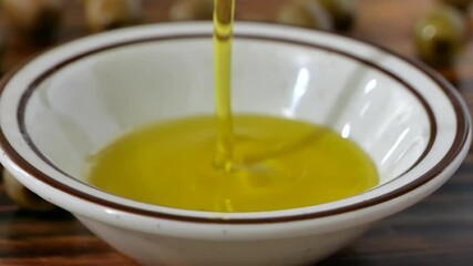 Wall Mural - Pouring olive oil onto a small bowl 