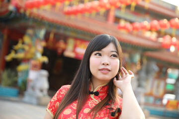 Wall Mural - beauty woman wear red cheongsam looking and smile in chinese new year