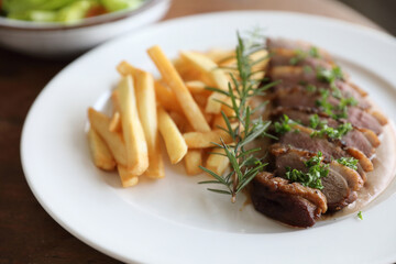 Wall Mural - Duck magret confit with chips on wood table