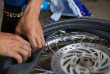 A Close-up Of The Wheels Of A Motorbike Is Being Removed By A Mechanic To Recap And Change Tires Due To Leaks.