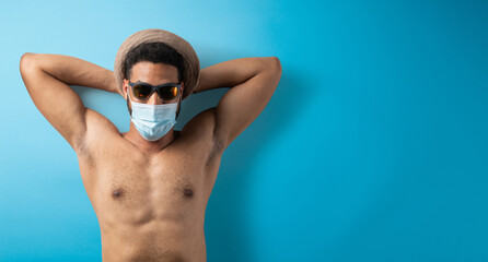 Flat lay top view portrait of young man with face mask, summer holiday, coronavirus and travel concept.