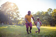 © liderina - African American father and son in nature.  Son and dad running together.