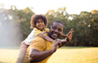 © liderina - African American father and daughter having fun outdoors.