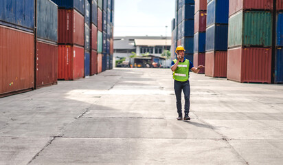 Wall Mural - Professional engineer container cargo foreman in helmets working standing and using walkie talkie checking stock into container for loading.logistic and business export