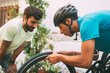 © Daniel - two young boys changing a bike wheel outside. cyclist with a helmet changing a flat bike wheel.