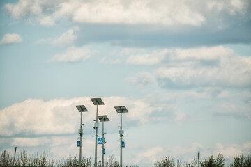  Solar panels and road signs on the background of the sky with clouds. Selective focus.