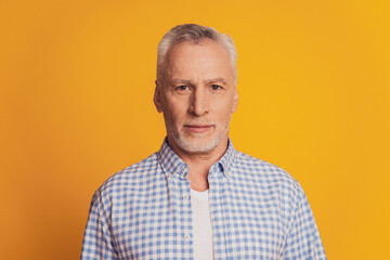 Portrait of pensive serious with white bristle old man isolated on yellow background