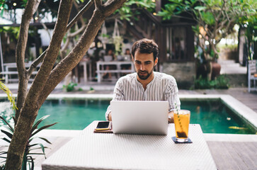 Young bearded man working on laptop