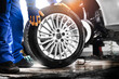 © Milan - Auto mechanic working in garage and changing wheel alloy tire.