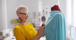 © TommyStockProject - Dressmaker making custom clothing for clients holding needles standing near mannequin in tailor shop.