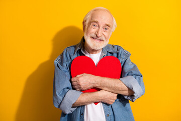 Sticker - Photo of happy positive smiling cheerful grandfather hug embrace big red paper heart isolated on yellow color background