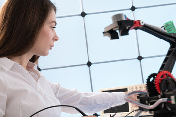 Wall Mural - A young woman writes an algorithm for the robot arm. Science Research Laboratory for Robotic Arm Model. Computer Laboratory