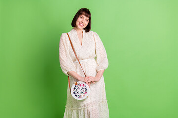 Sticker - Photo portrait of smiling girl wearing dotted dress clutch isolated on pastel green color background