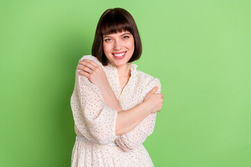 Wall Mural - Photo of young attractive girl happy positive smile hug cuddle embrace herself comfort isolated over green color background