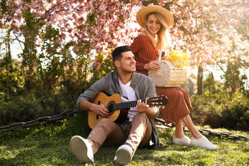 Canvas Print - Lovely couple having picnic in park on sunny spring day