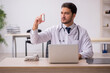 © Elnur - Young male doctor holding pills in the clinic