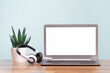 Laptop. Mockup blank screen and headphones on wooden desk. Distant learning. working from home, online courses or support minimal concept. Helpdesk or call center headset