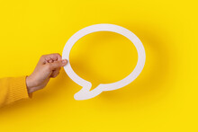 Dialogue Bubble In Hand Over Yellow Background