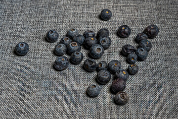 Handful of ripe blueberries on gray-dyed linen cloth