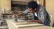 © BalanceFormCreative - Young black man carpenter working in his workshop.
