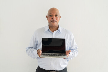 Wall Mural - Portrait of happy smiling senior old elderly business Black African American man person showing a blank screen computer laptop notebook in technology device isolated on white background. Empty space.