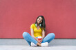 © wpadington - Full-length portrait of beautifull smiling dark skinned girl student sitting outdoors relaxing drinking coffee and enjoying sunny day