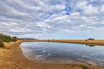 Wall Mural - Small lake near sea sand with sky reflection