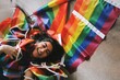 young woman surrounded with rainbow lgbtqia+ pride flags smiling happy 