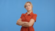 © Red Stock - Young Angry and furious woman posing with hands crossed isolated over blue background. Portrait of angry woman.