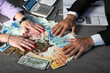 © Sabrina Umansky - Businessman Hands holding and giving for a contract a fan of money of Israeli New Shekels, GBP and dollars. Cropped image of Hand holds banknotes. Selective focus. A man and a women hands hold a money