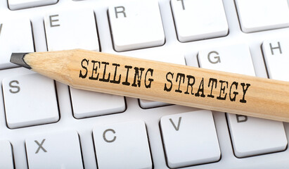 SELLING STRATEGY text on pencil on the keyboard on background