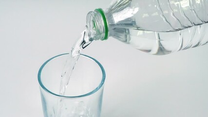 Wall Mural - Close up slow motion pouring drink water into drinking glass