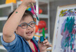 © Bangkok Click Studio - Happy girl with Down syndrome painting on easel