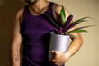 © Narayan - man holding a potted plant for decoration, houseplant concept