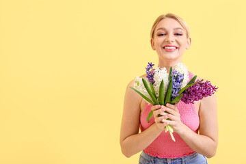 Wall Mural - Beautiful young woman with hyacinth flowers on color background