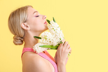 Wall Mural - Beautiful young woman with hyacinth flowers on color background