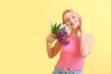 Wall Mural - Beautiful young woman with hyacinth flowers on color background