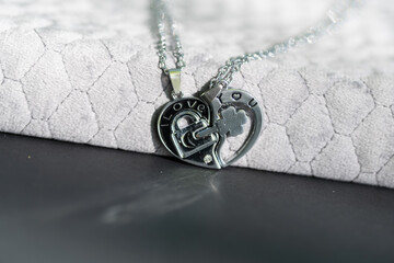 Canvas Print - Couple set pendant necklace half of heart shoot outdoors in a sunny day closeup. Selective focus. High quality photo