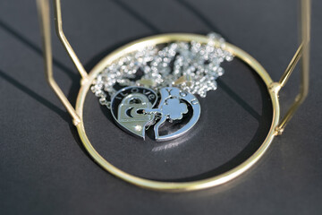 Canvas Print - Couple set pendant necklace half of heart shoot outdoors in a sunny day closeup. Selective focus. High quality photo