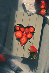 strawberries on table, illuminated by ray of light from window, real food, homemade