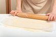 Cook rolls out the dough thinly with rolling pin. Preparing the dough for baking.