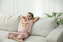 Little Girl Resting On Comfortable Sofa In Living Room